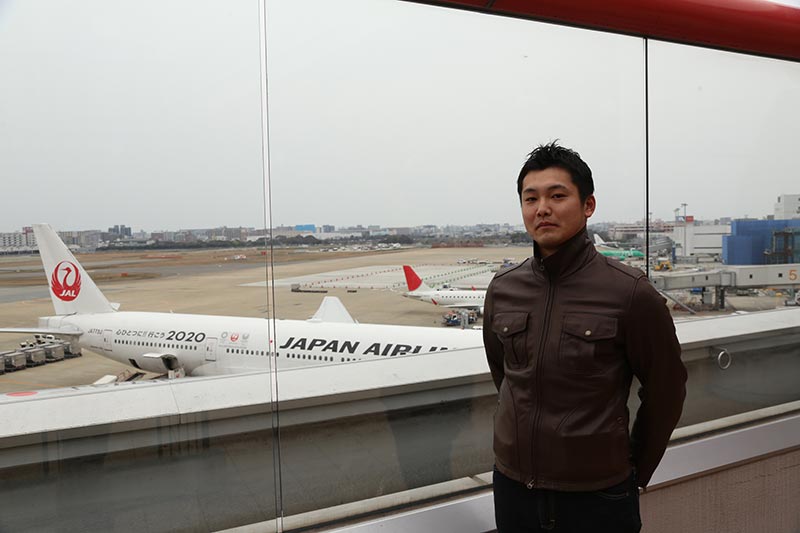 写真：飛行機の前に立つ岩永さん